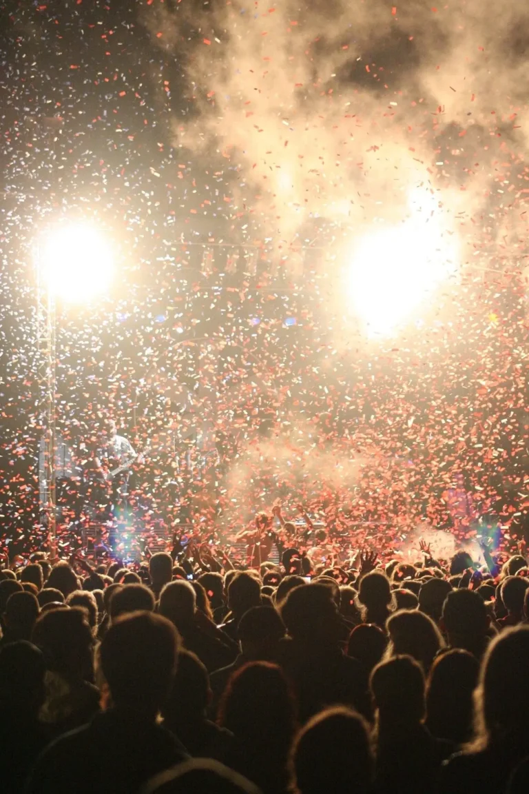 Crowd at a live event lit by moving head stage lighting beams