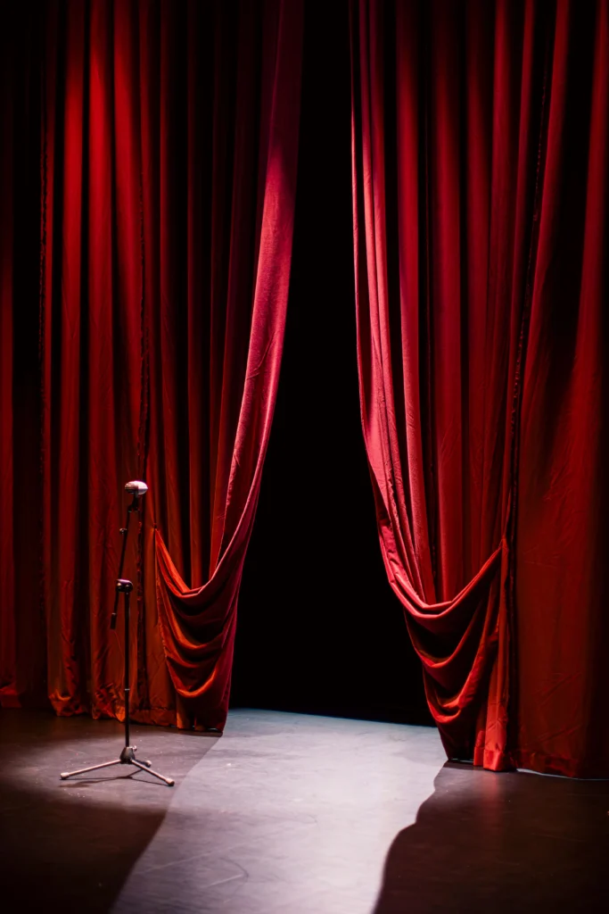 Red stage curtain lit with warm stage lighting hire before a show